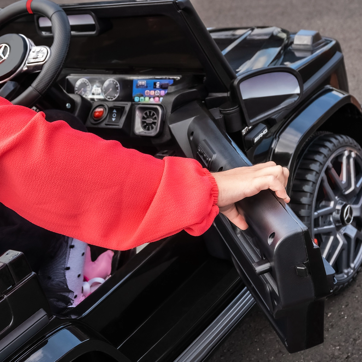 Zwei Türen zum Öffnen Mädchen öffnet mit Hand die Tür des Kinder-Elektroautos, um einzusteigen